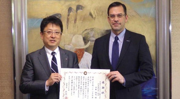 熊本市を訪問し、大西市長（左）から感謝状を送られた平野社長（右）